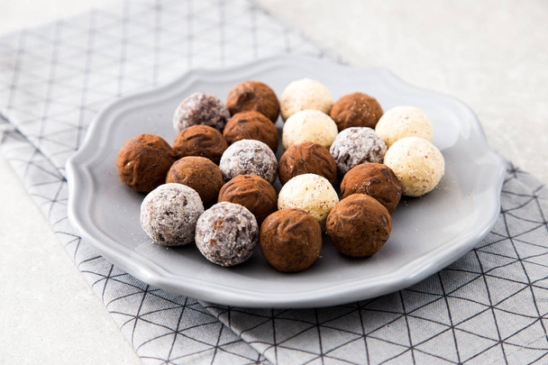 Různé čokoládové lanýže s kakaový prášek, kokos a nasekané lískové ořechy na dezertní talířek - Fotografie, Obrázek