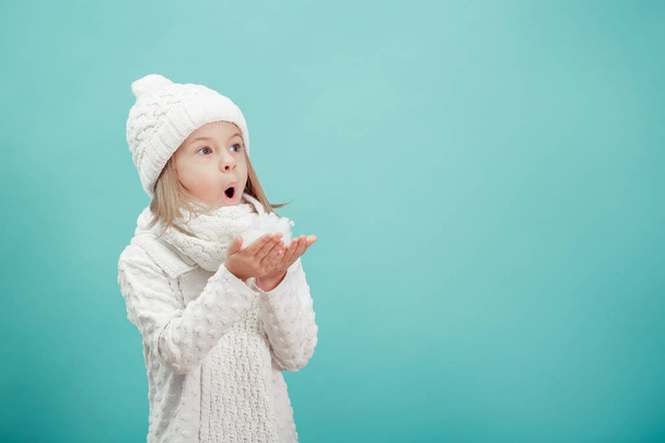 μικρό ξανθό κορίτσι σε ένα λευκό καπέλο και κασκόλ - Φωτογραφία, εικόνα