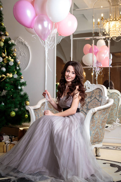 beautiful young woman in luxury evening dress with air balloons over christmas background - Φωτογραφία, εικόνα