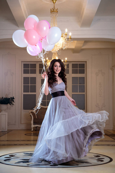 beautiful young woman in luxury evening dress with air balloons in interior - Фото, зображення