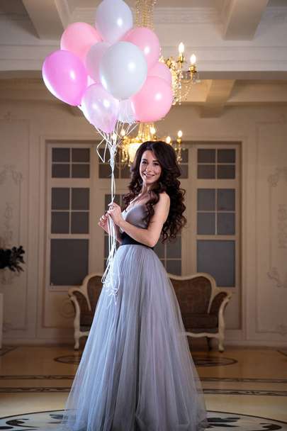beautiful young woman in luxury evening dress with air balloons in interior - Zdjęcie, obraz