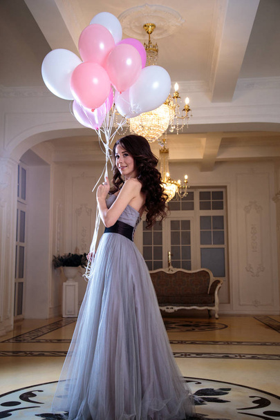 beautiful young woman in luxury evening dress with air balloons in interior - Φωτογραφία, εικόνα