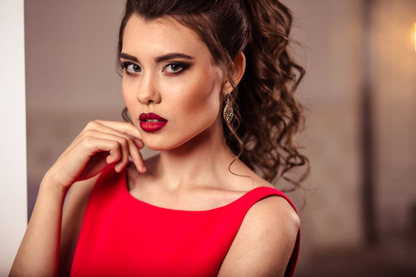 young lady in a gorgeous red evening dress in interior - Fotografie, Obrázek