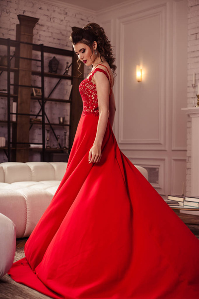 young lady in a gorgeous red evening dress in interior - Zdjęcie, obraz