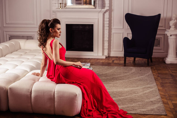young lady in a gorgeous red evening dress in interior - Foto, Imagem