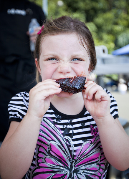 Дівчина їсть ребро барбекю
 - Фото, зображення