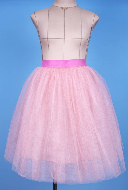 Schaufensterpuppe in rosa Prinzessinnenrock auf blauem Hintergrund - Foto, Bild