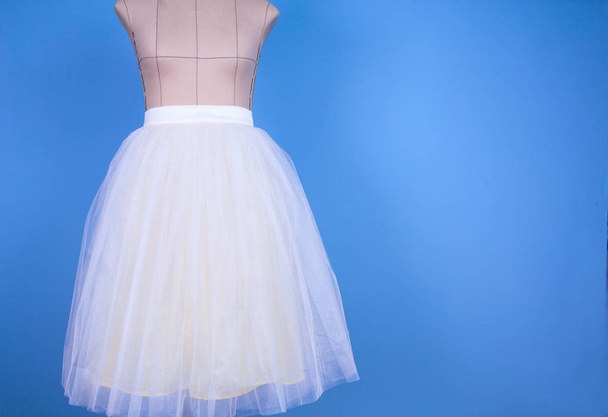 Μανεκέν σε λευκό φούστα σε γραμμή πρινσές σε μπλε φόντο - Φωτογραφία, εικόνα