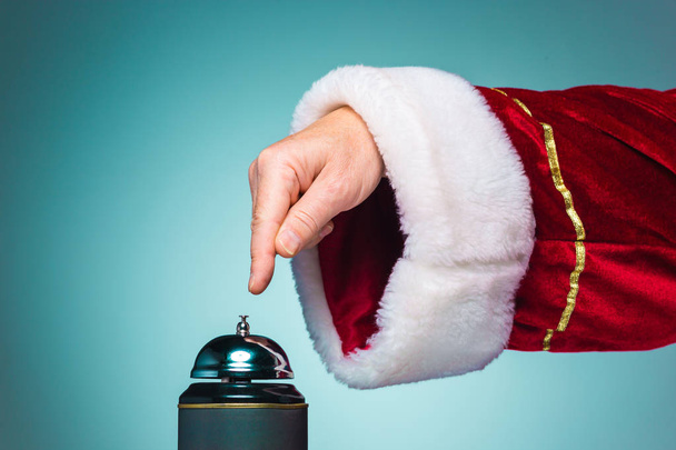 Mano de Santa Claus presionando la campana
 - Foto, imagen