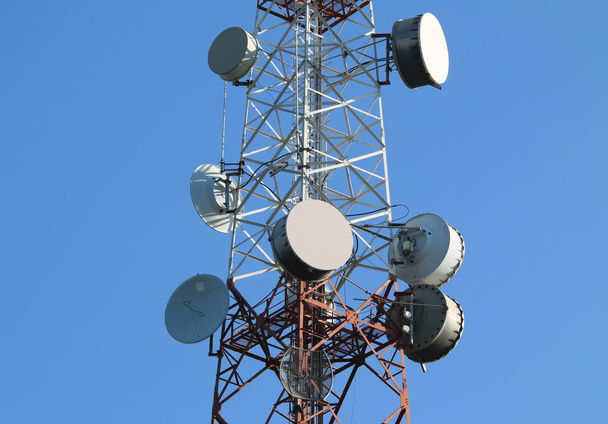 Спутниковая тарелка на телекоммуникационной радиоантенной башне
. - Фото, изображение
