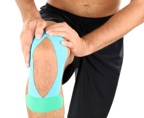 Physio tape applied onto male knee, isolated on white - Foto, Imagem