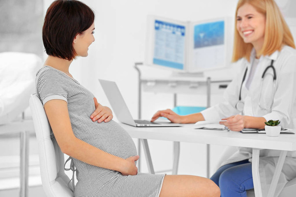 Pregnant woman visiting doctor - Foto, afbeelding