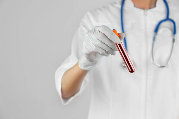 Hand in glove holding test tube   - Фото, изображение