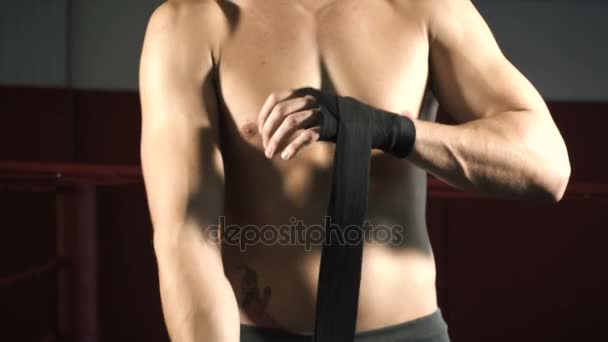 男のボクサーは、彼の手に包帯を引っ張る - 映像、動画