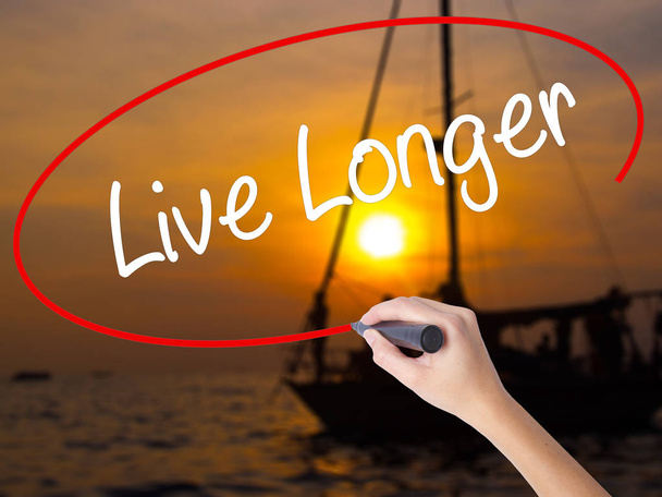 Woman Hand Writing Live Longer with a marker over transparent bo - Photo, Image
