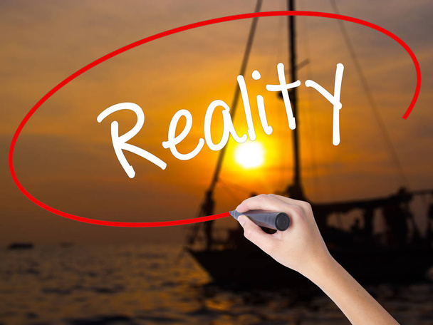 Woman Hand Writing  Reality with a marker over transparent board - Photo, Image
