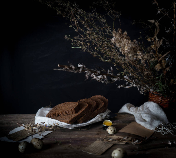 still life. vintage. a simple country breakfast on  wooden table. bread, eggs. black background - Foto, Imagem