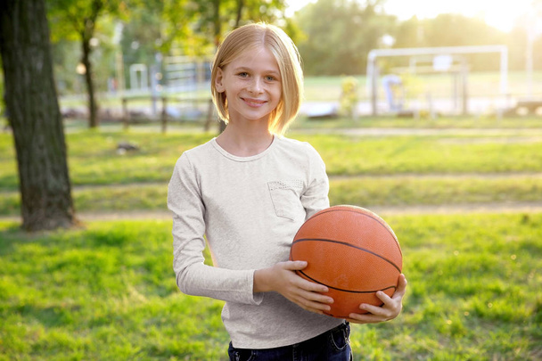 Cute girl with basketball ball on street - Foto, Imagen