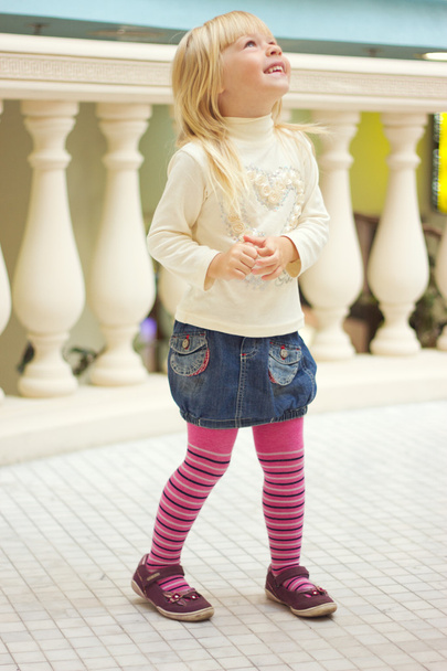 Girl 3 years old in a denim skirt and pink tights - Photo, Image