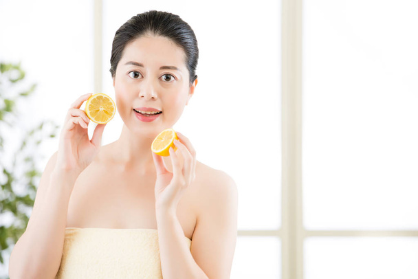 Beautiful asian woman holding slices of lemon. healthy beauty  - Fotografie, Obrázek