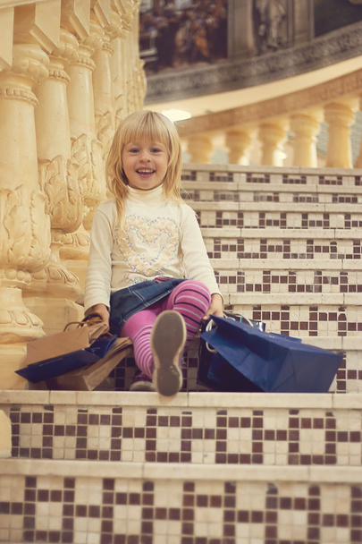 menina 3 anos de idade sentado com compras
 - Foto, Imagem