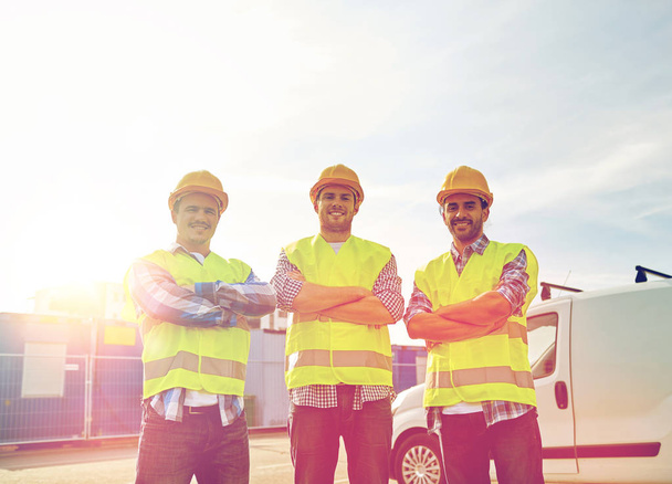 happy male builders in high visible vests outdoors - Fotografie, Obrázek