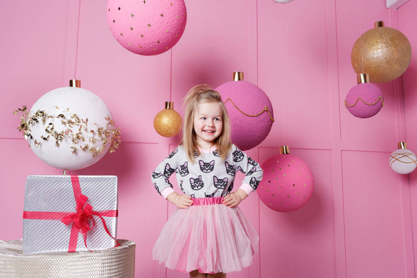 Pretty girl child 3 years old in a dress. Baby in Rose quartz room decorated holiday. - Photo, Image