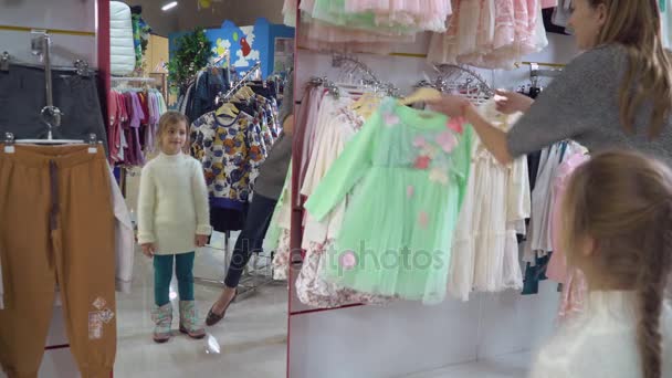 Familie proberen op slijtage kleding in de winkel. - Video