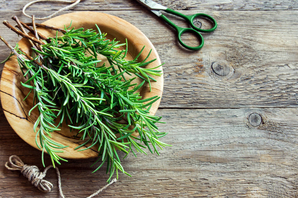 Rosemary leaves bunch close-up. Fresh Organic flavoring plants on wooden table with copy space. Seasonings, cooking, ingredients for healthy food. - Fotoğraf, Görsel