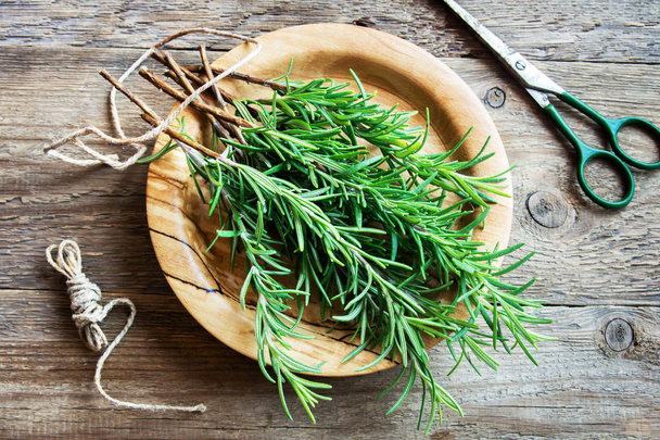 Rosemary leaves bunch close-up. Fresh Organic flavoring plants rosemary on wooden table with copy space. Seasonings, cooking, ingredients for healthy food. - Fotó, kép