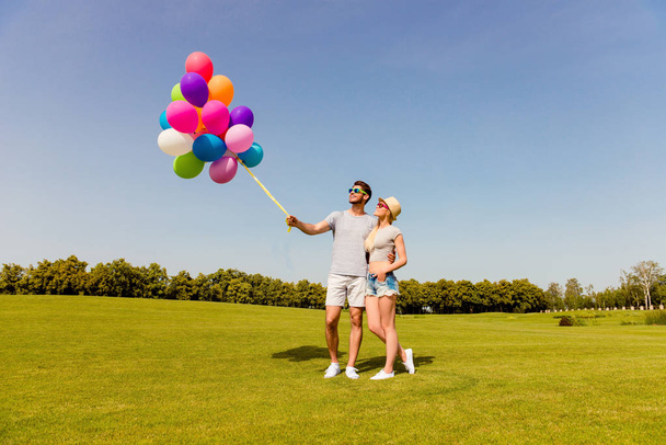 Portrait of two lovers with balloons having date in the park - Φωτογραφία, εικόνα
