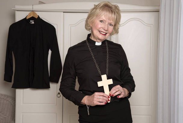 Mujer religiosa vestida de negro sosteniendo una cruz
 - Foto, Imagen
