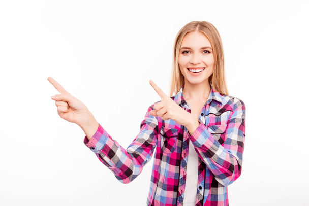 Cheerful  young woman with beaming smile pointing away - Foto, afbeelding