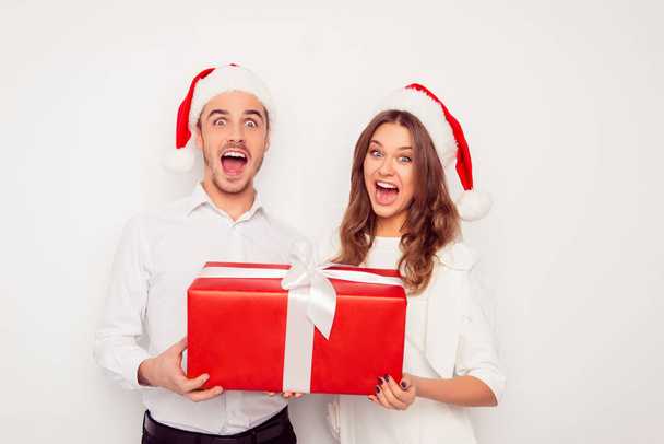 Wow! Excited man and woman holding big christmas gift - Photo, Image