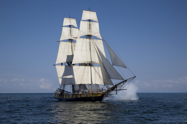 hoog schip met Amerikaanse vlag zeilen op blauwe wateren - Foto, afbeelding