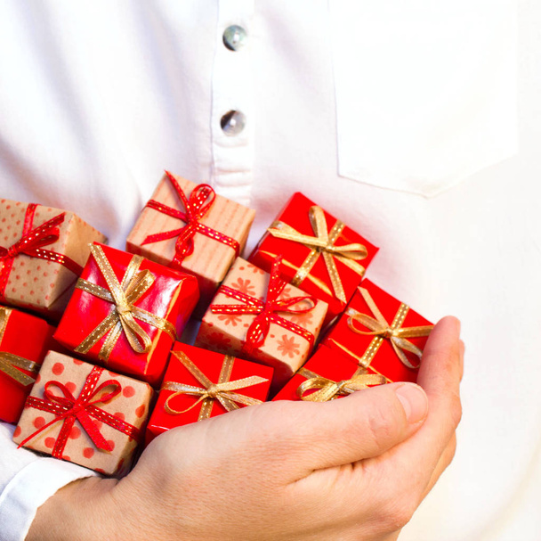 Homme tenant pile de petits cadeaux
 - Photo, image
