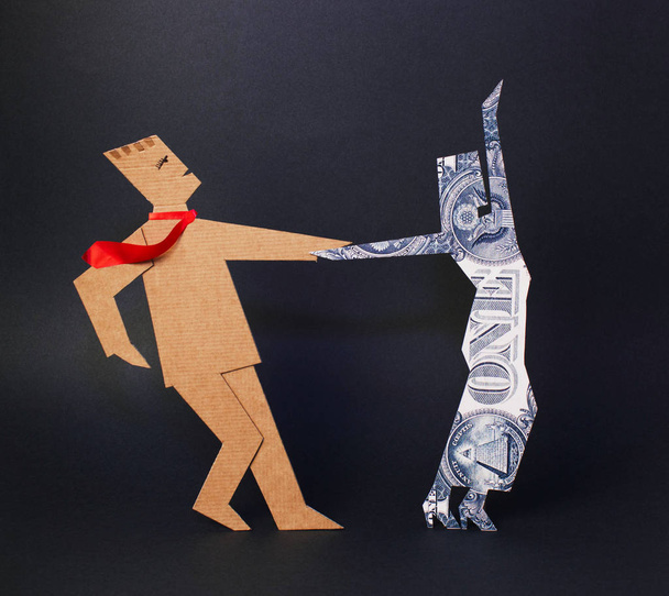 Paper man is a successful businessman dancing with a woman made of dollar on a dark background - Fotoğraf, Görsel
