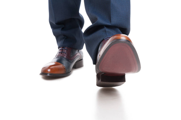 Close-up van man schoenen en broek in positie lopen - Foto, afbeelding