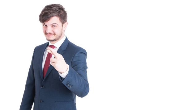 Handsome man wearing suit making fingers crossed gesture - Zdjęcie, obraz