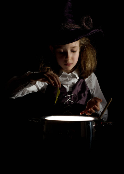 Küçük kız cadı kostüm iksir hazırlama. - Fotoğraf, Görsel
