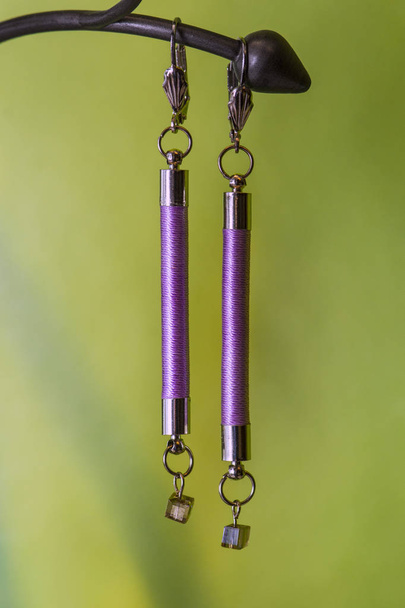 roze Handgemaakte oorbellen op wazig groene achtergrond - Foto, afbeelding