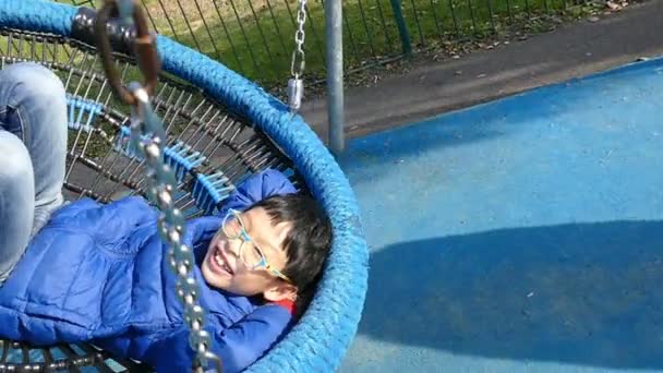 Asijské boy usmívající se houpat v houpací židli, pomalý pohyb - Záběry, video