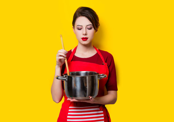鍋とスプーンを持つ若い主婦  - 写真・画像