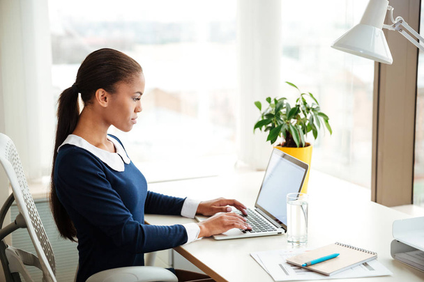 Африканская деловая женщина с ноутбуком в офисе
 - Фото, изображение