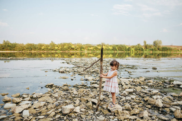 girl holding a dry branch of the river - Foto, Imagem