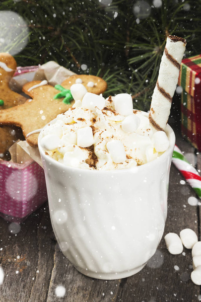 Cup of hot cocoa with cream and gingerbread on a dark background - Fotó, kép