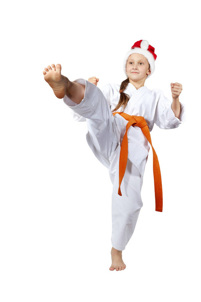 Karateka in the cap of Santa Claus hits a kick leg forward - Photo, Image