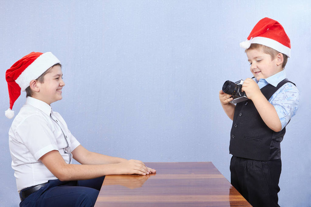 Fratelli in berretti di Babbo Natale stanno fotografando sulla macchina fotografica
 - Foto, immagini