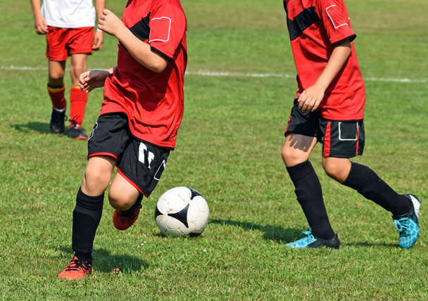 Kinderen zijn te voetballen in de zomer - Foto, afbeelding