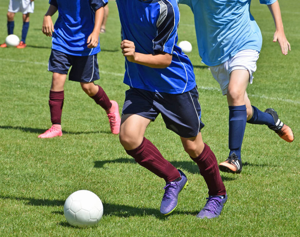 Jonge jongens zijn te voetballen - Foto, afbeelding